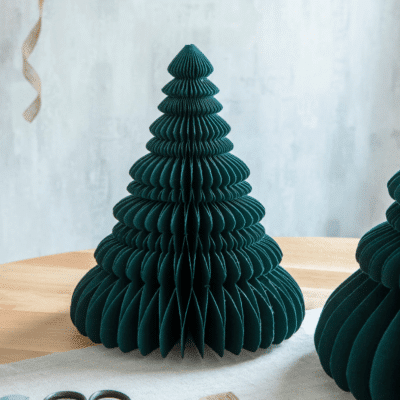 The small Maddox Tree in Forest Green is a delightful paper-crafted holiday decoration. This charming tree adds a festive touch to tabletops or spaces, offering a whimsical yet eco-friendly seasonal accent.